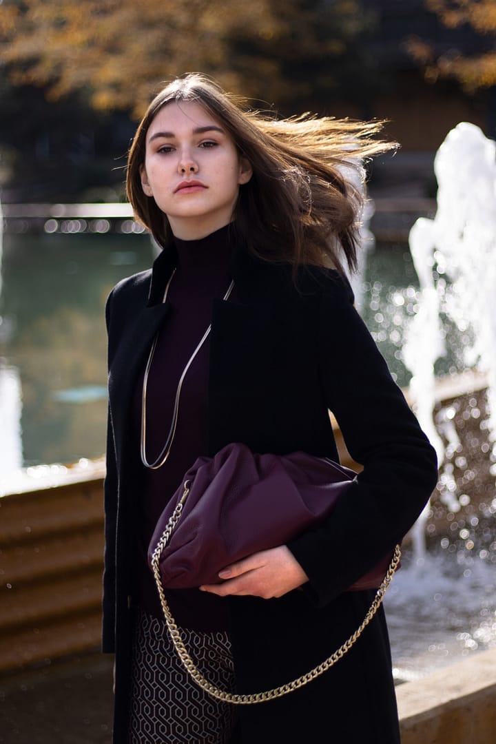 Kabát z 80% recyklovaných vláken, vyštíhlený s tzv. obrácenou fazónkou, 95 cm dlouhý v barvě černé